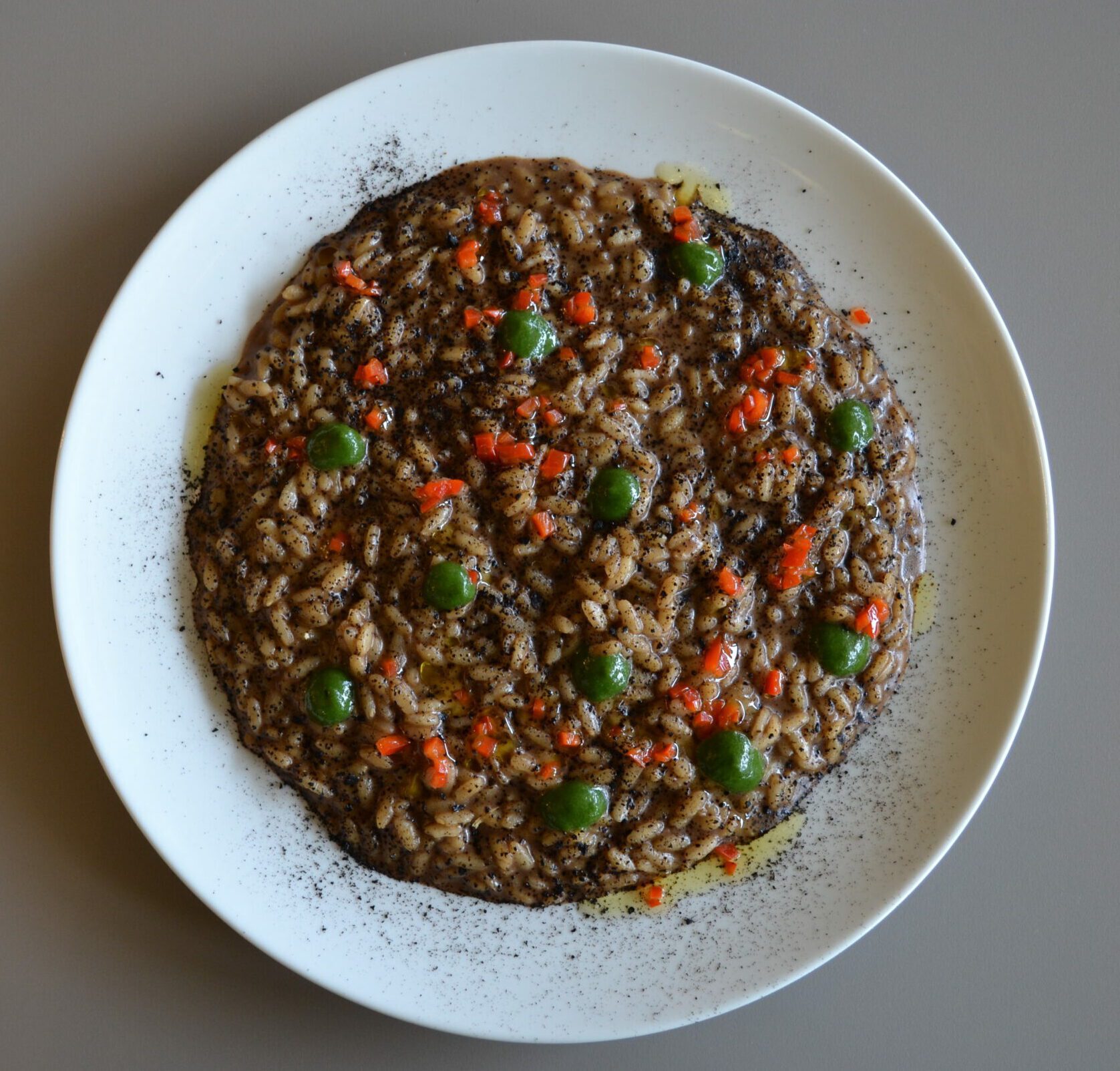 Risotto A.O.P. con aglio nero, peperoncino fresco e salsa al prezzemolo.
