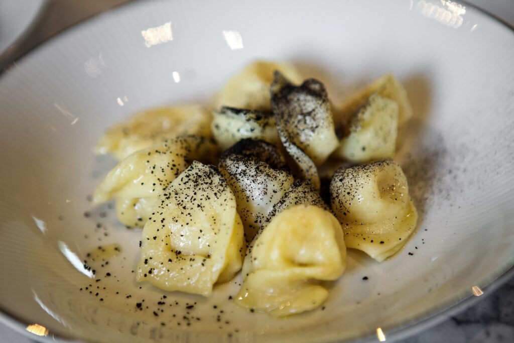 Cappelletti romagnoli con olio e polvere di aglio nero.