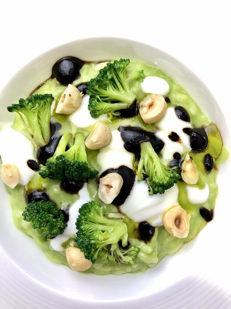 Risotto alla crema di broccolo con aglio nero, nocciole e cimette di broccolo.