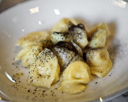 Cappelletti romagnoli con olio e polvere di aglio nero.