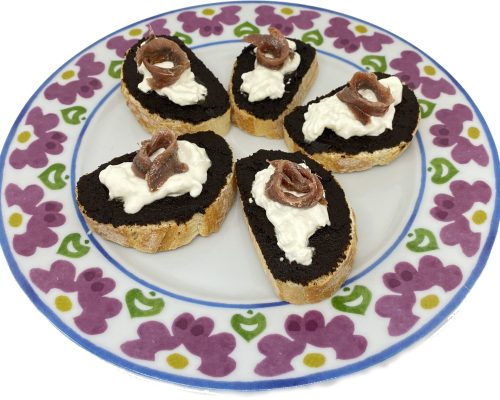 Crostini con aglio nero, burrata e acciughe.