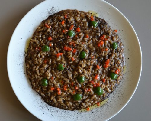 Risotto A.O.P. con aglio nero, peperoncino fresco e salsa al prezzemolo.